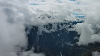 Aerial view of snowcapped mountains in clouds
