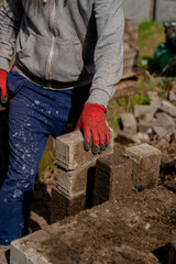 young man in red gloves holding a brick