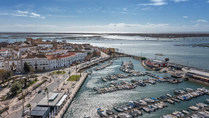 Traditional Portuguese town of Faro on oceanfront with old architecture, filmed by drone. Ria...