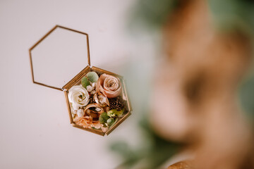 Valmiera, Latvia- July 28, 2024 - An open hexagonal glass box with elegant wedding rings nestled...
