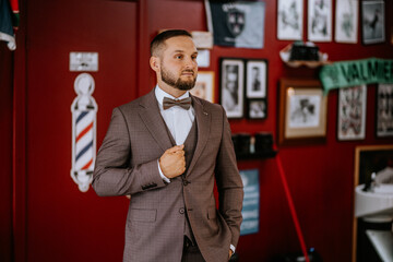 Valmiera, Latvia- July 28, 2024 - a man in a barber shop, dressed in a suit with a bow tie,...