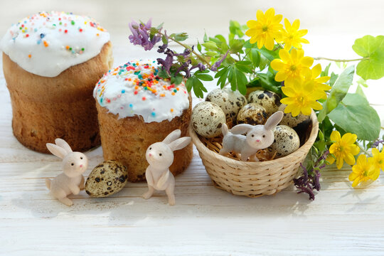 Easter holiday. Easter sweet cakes (kulich, paska), cute bunny and eggs with flowers on table close up, white background. festive composition for spring season. 
