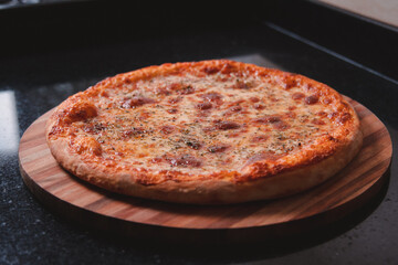 Mozzarella pizza on a black granite table.