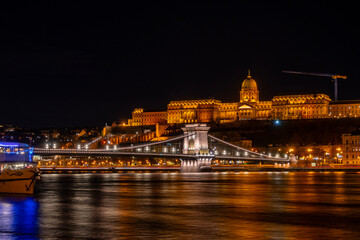 Fototapeta premium Night photo of Budapest city waterfront with Castle Hill and famous landmarks rising above Danube river