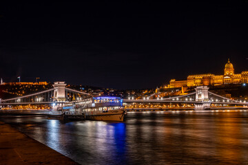 Night photo of Budapest city waterfront with Castle Hill and famous landmarks rising above Danube...