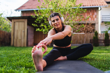 One young caucasian woman is doing yoga and exercise in backyard	
