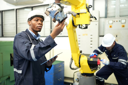 Engineer check and control welding robotics automatic arms machine in intelligent factory automotive industrial with monitoring system software. Digital manufacturing operation.