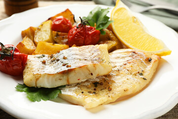 Tasty cod cooked with vegetables on table, closeup