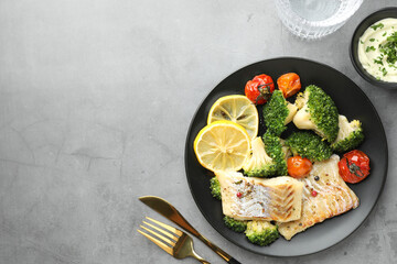 Tasty cod cooked with vegetables served on grey table, flat lay. Space for text