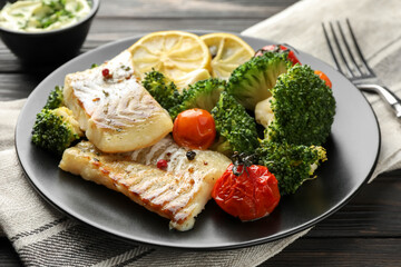 Tasty cod cooked with vegetables served on table