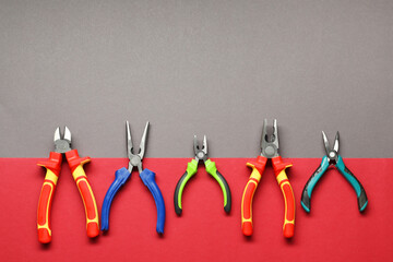 Different pliers on color background, flat lay. Space for text