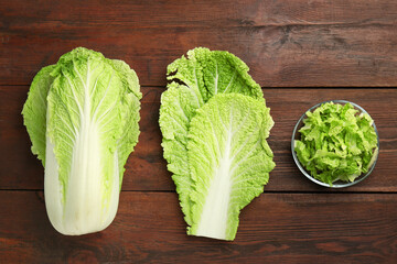 Whole and cut fresh Chinese cabbage on wooden table, top view - obrazy, fototapety, plakaty