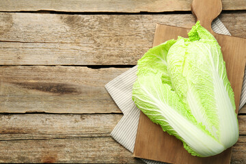 Fresh ripe Chinese cabbage on wooden table, top view. Space for text