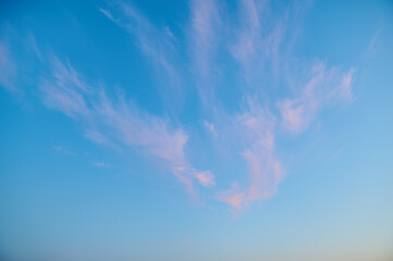Blue sky with a delicate pink-orange cloud