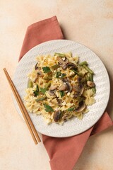 Vegetarian pasta with mushrooms, parsley, string beans and cheese on orange textured table, top view