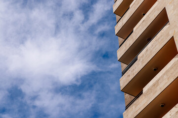 Geometric perfection. A part of modern apartment building against partly cloudy sky.