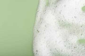 Tuinposter White fluffy foam on green background, top view. Space for text © New Africa