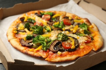 Delicious vegetarian pizza with mushrooms, cheese and vegetables in box on table, closeup