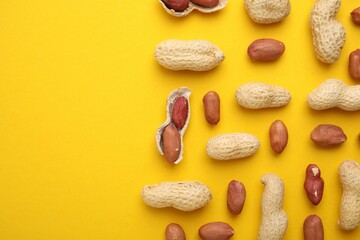 Fresh peanuts on yellow table, flat lay. Space for text