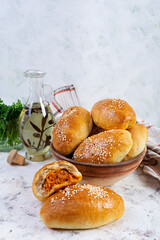 Delicious cabbage pies on wooden background. Baked homemade pirozhki with cabbage