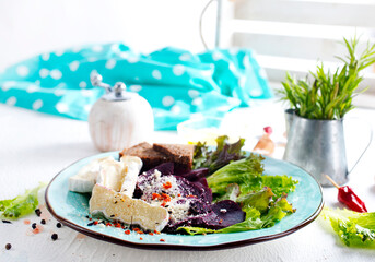 Camambert, beet salad and bread on blue plate