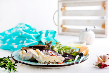 Camambert, beet salad and bread on blue plate