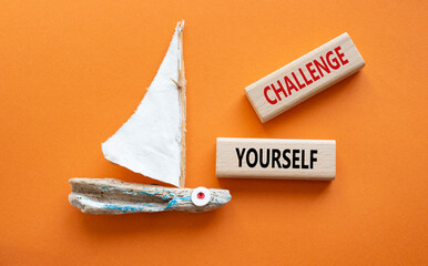 Challenge yourself symbol. Wooden blocks with words Challenge yourself. Beautiful orange background...