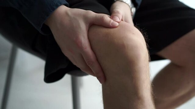 Knee pain.
The guy has a pain in his leg and he massages his kneecap