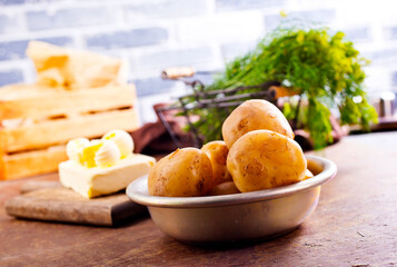 Fresh raw baby potato in bowl on wooden background.