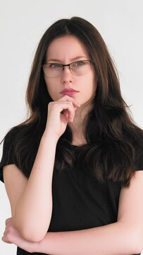 Vertical video. Confused thinking. Problem solution. Pensive skeptic smart woman in glasses considering idea making decision plan enthusiastic smiling isolated on white.