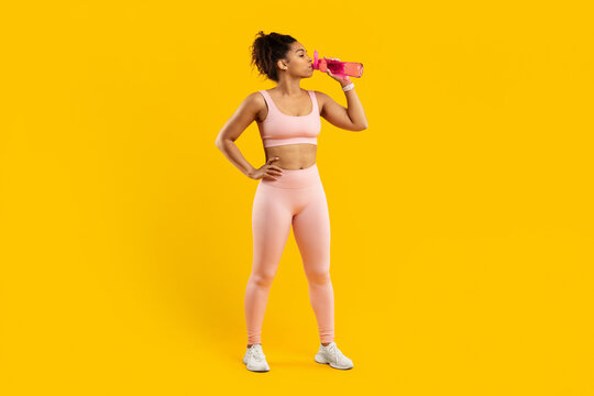 African american lady athlete drinking water post workout