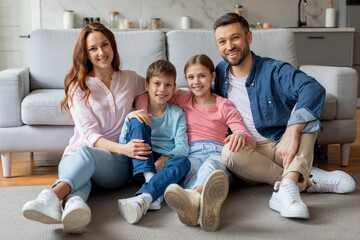 Casual family sitting together at home in living room - obrazy, fototapety, plakaty