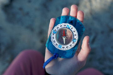 Compass in a kid hand with sea waveson background