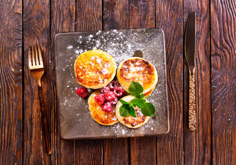 Cottage cheese pancakes with raspberries on wooden background, breakfast or lunch - 786632845