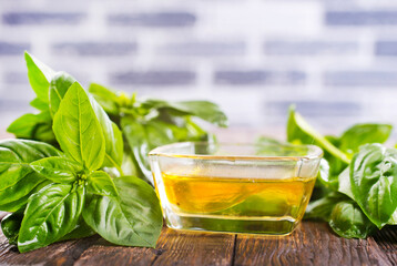 Basil oil and fresh herbs on wooden table - 786632849