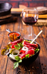 salad with jamon and red wine on wooden table - 786633258