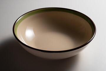 Empty rustic beige soup plate bowl with colored edge