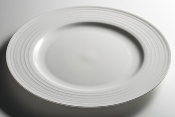 Empty white dinner plate with edge decorated with concentric circles in relief