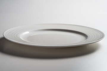 Empty white dinner plate with edge decorated with concentric circles in relief