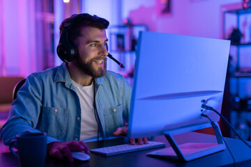 Gamer calmly using computer at night at home