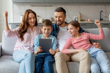 Happy family using tablet on the sofa