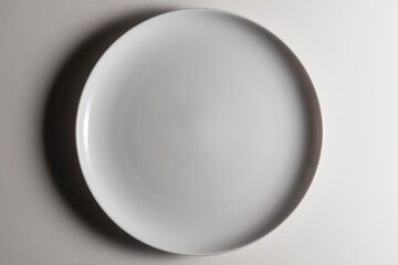 Empty white dinner plate without wing with slightly curved edge with a modern design