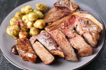 Delicious fried beef meat and vegetables on black table, closeup