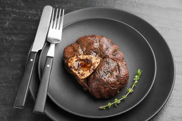Schilderijen op glas Tasty grilled beef meat served on black table, closeup © New Africa
