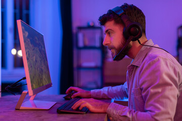Engaged man gamer playing in neon lighting
