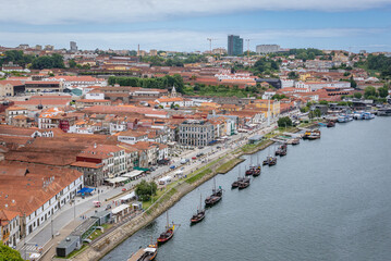Douro River bank in Vila Nova de Gaia city, Portugal. View with traditional Rabelo boats and wine caves