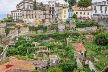 Ruined buildings between Rue de Dom Hugo street and Dom Luis Bridge in Porto city, Portugal. Episcopal palace on background