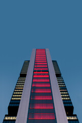 Naklejka premium Illuminated modern skyscraper against twilight sky