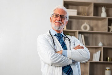 Mature senior male doctor in glasses medical uniform smiling looking at camera in hospital or doctor office. General practitioner GP therapist professional healthcare expert in clinic. Healthcare