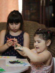 Girls playing with painting with their hands
